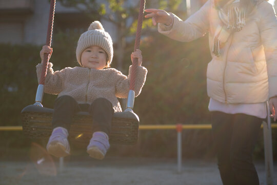 公園のブランコで遊ぶ3歳の女の子