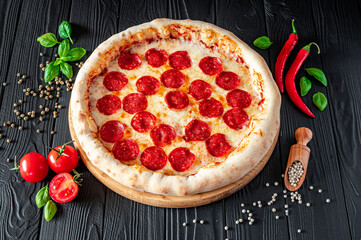 Tasty pepperoni pizza and cooking ingredients tomatoes basil