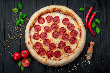 Tasty pepperoni pizza and cooking ingredients tomatoes basil