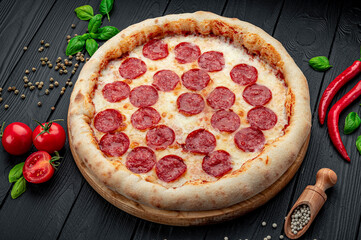 Tasty pepperoni pizza and cooking ingredients tomatoes basil