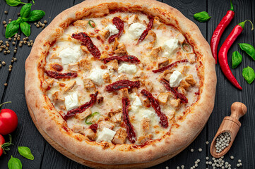 Big and tasty pizza with sun-dried tomatoes and feta cheese