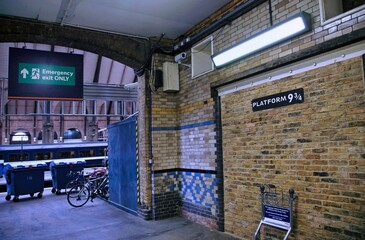 Naklejka premium Platform 9 and 3/4 at King's Cross Railway station, with a luggage trolley passing through the wall, as in the Harry Potter stories