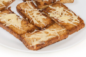 Hot open sandwiches with grated cheese on dish, close-up