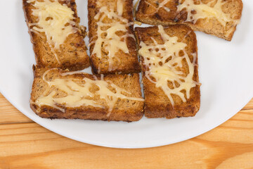 Hot open sandwiches with grated cheese on dish, close-up