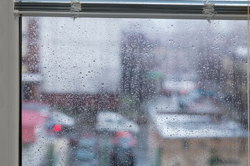 Window covered with water drops during a rain, inside view