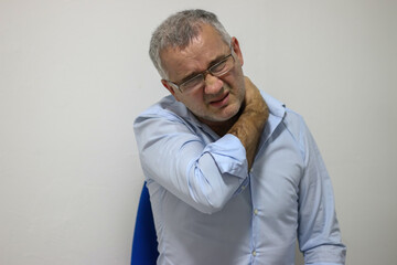 Obraz premium Neck pain. Unhappy mature man suffering from neck pain at office