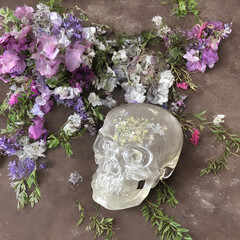 glass skull surrounded by flowers, AI generated