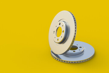 Brake disks on yellow background. Spare parts for car service. Automotive components. Copy space. 3d render