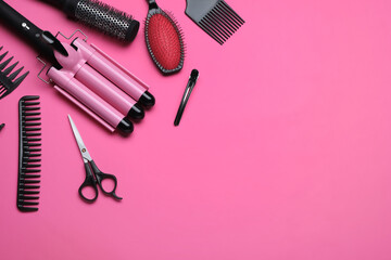 Flat lay composition of professional hairdresser tools on pink background, space for text