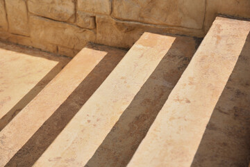 Closeup view of beautiful stone stairs near brick wall outdoors