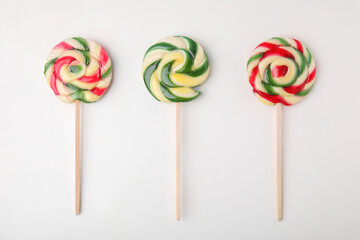 Colorful lollipops on white background, flat lay