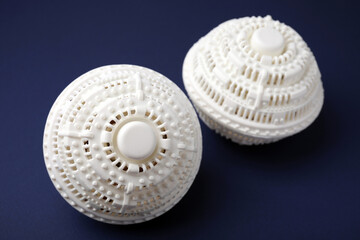 Dryer balls for washing machine on dark blue background, closeup