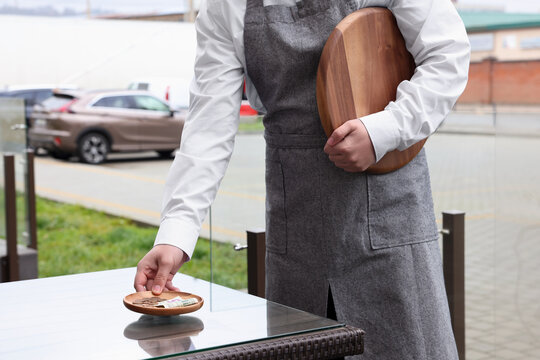 Waiter Taking Tips From Wooden Table In Outdoor Cafe, Closeup