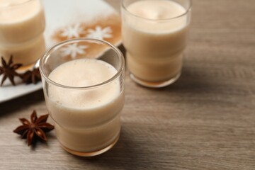 Delicious eggnog with anise on wooden table. Space for text
