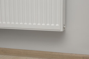 White wall with modern panel radiator indoors. Heating system