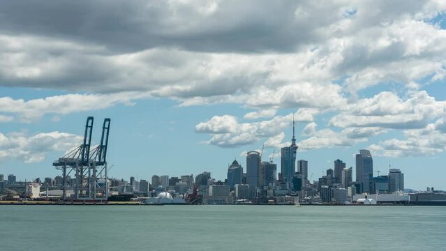 Time lapse of Auckland City centre viewed across the Waitematā Harbour from Devonport. White, puffy, cumulus clouds forming over the city.