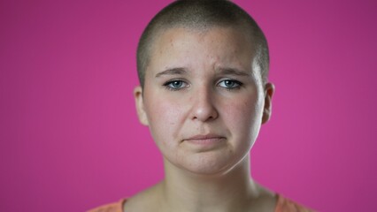 Pretty gender fluid non binary young woman 20s did not get enough sleep feel sick. Closeup portrait isolated on pink background in studio.