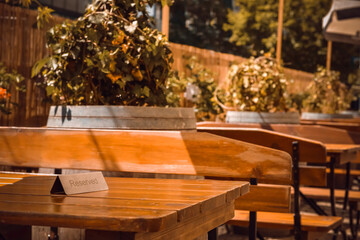 Sign Reserved on wooden table in outdoor cafe. Space for text