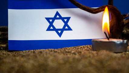 Israeli flag and candles burning in front of it, Holocaust memory day