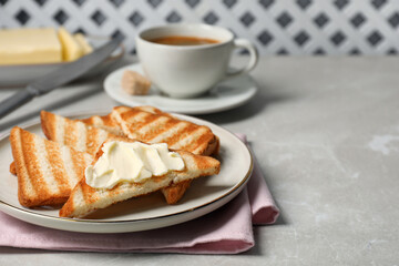 Tasty toasts with butter on light grey marble table. Space for text