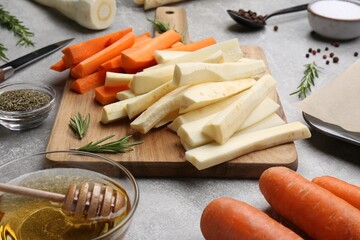 Composition with parsnips, carrots and other products on light grey table