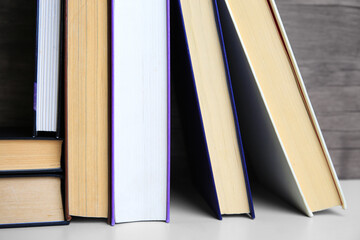 Collection of different books on white shelf, closeup