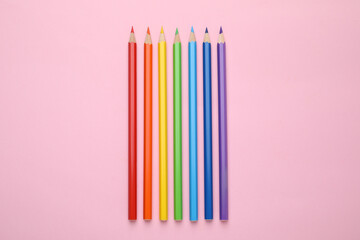 Colorful wooden pencils on pink background, flat lay