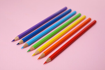 Many colorful wooden pencils on pink background