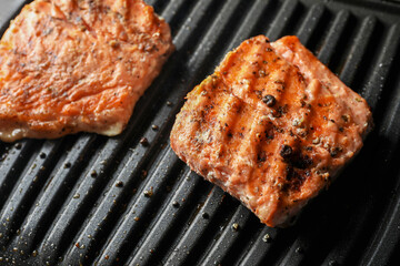 Tasty salmon cooking on electric grill, closeup