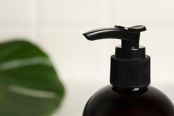 Shampoo bottle on blurred background, closeup. Space for text