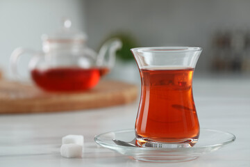 Glass of traditional Turkish tea on white marble table, space for text