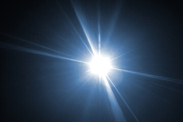 Blue light lens flare on black background.