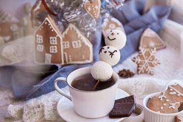 Obraz na płótnie Canvas Winter aesthetic morning. Marshmallow snowman in hot chocolate, ginger cookies near Christmas tree. Cozy warm home.