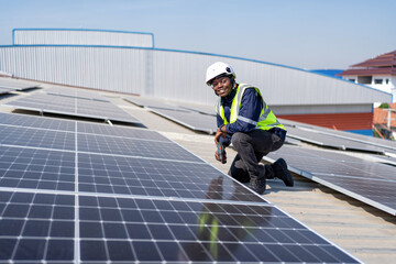 Engineer on rooftop kneeling next to solar panels photo voltaic with tool in hand for installation