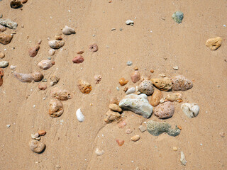 Fototapeta na wymiar Background of rocks and pink sand on the beach seashore