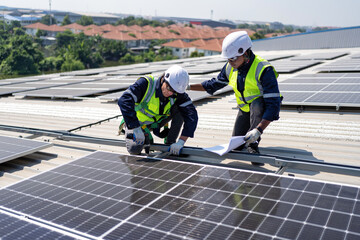 Engineer on rooftop kneeling next to solar panels photo voltaic check drawing for good installation