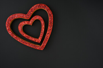 Two sparkly red heart shaped frames on a black background, celebrating love on Valentine’s Day
