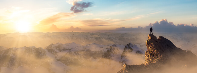Abenteuerlustiger Wanderer, der auf einem eisigen Gipfel mit felsigen Bergen im Hintergrund steht. Abenteuerkomposit. 3D-Rendering-Felsen. Luftbild der Landschaft von BC, Kanada. Sonnenuntergang Himmel