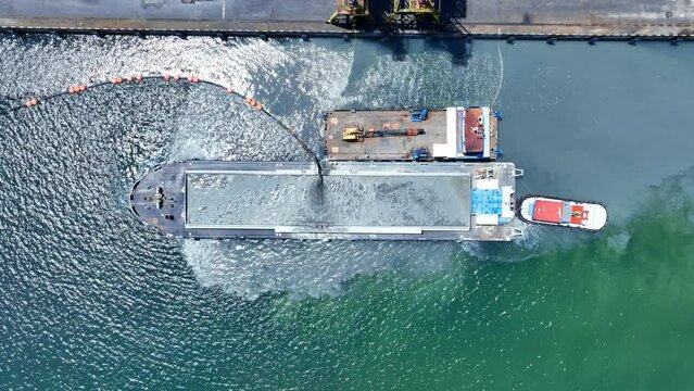 Dredging Vessel in action to keep waterways navigable, excavate and gathering sediments in the bottom and disposing at another location, Ship excavating material from a water environment