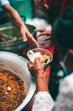 Concept of giving free food to the poor in the community : Volunteers handing out food to hungry people