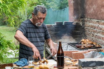 Person cooking an argentinian barbecue or asado - obrazy, fototapety, plakaty
