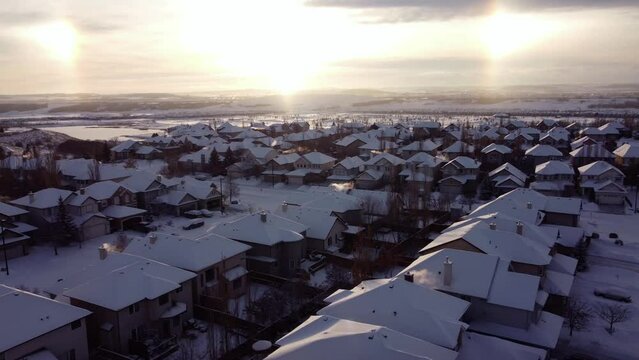 Sun dogs optical illusion over winter snowy community while flying drone