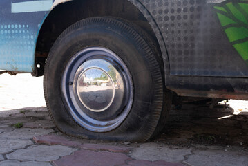 the deflated wheel of an old car