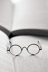 Fototapeta premium Education and schooling concept.Reading glasses close-up on the pages of a book .Symbol of study, knowledge and reading.