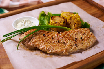 grilled steak with corn, sauce and vegetables