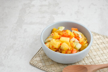 Acar or Pickles, made from diced carrot, pineapple, cucumber with chilli, vinegar, sugar, salt. 
