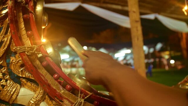Musician playing Thai classical traditional music on Thai Xylophone or Pat kon or La gyan hsaing or Khong mon or Kong mon or Pi Phat or Gong Mon or graduated brass gong chime