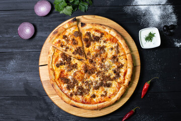 pizza with minced meat on a black background