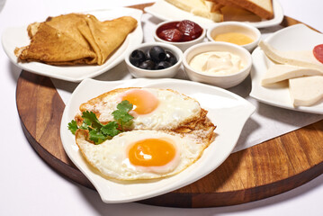 scrambled eggs, fried eggs in the foreground, breakfast