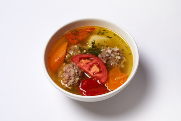 soup with meatballs in a plate on a white background